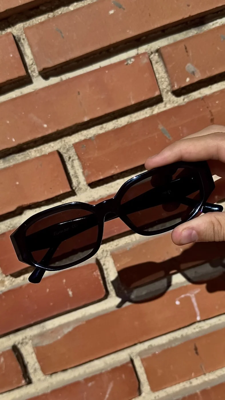 Fotografía de producto — gafas de sol Firmoo sobre un muro de ladrillo